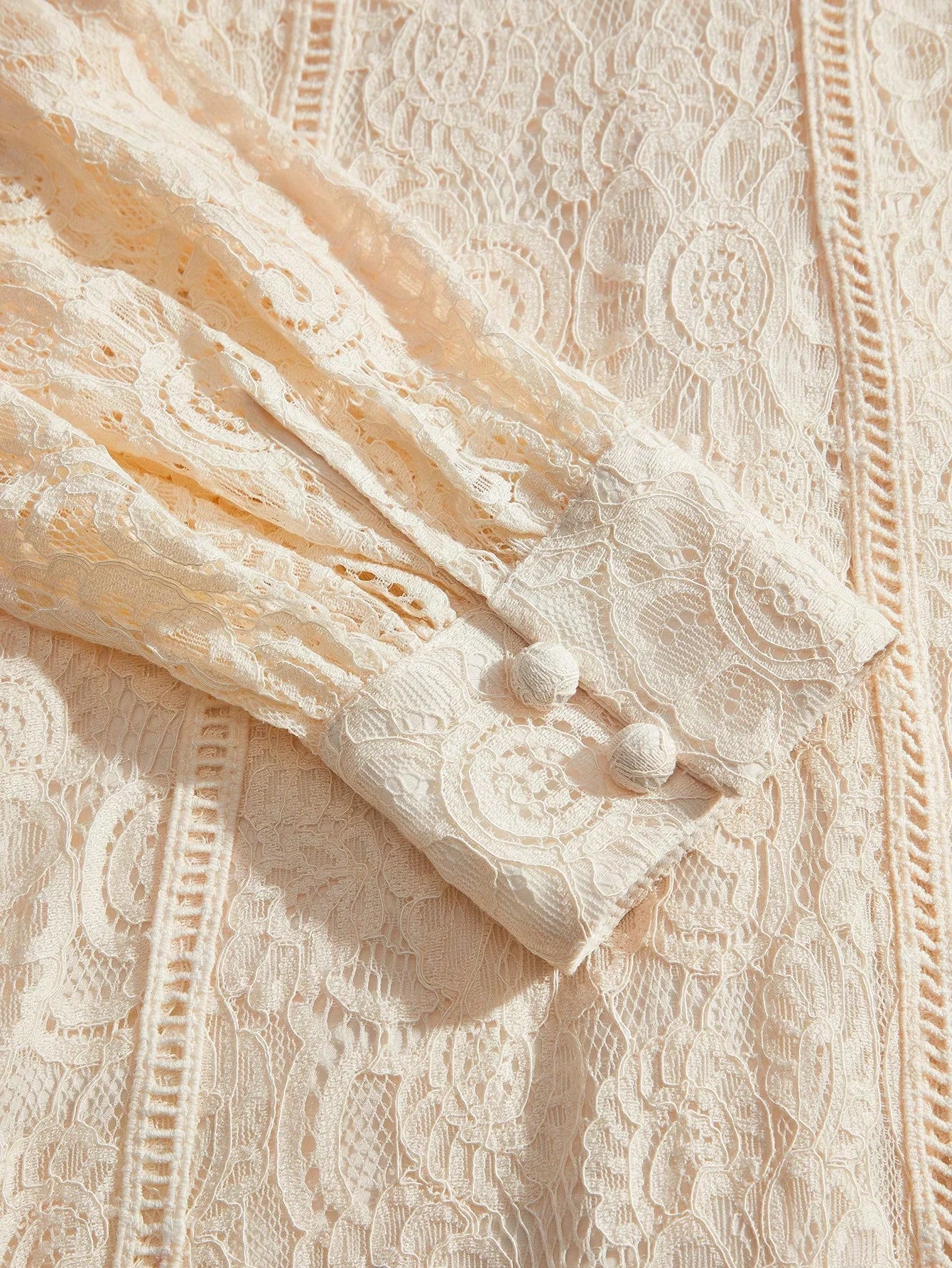 This delicate cream lace dress features intricate floral patterns and a soft, flowing fit that exudes elegance. The buttoned.