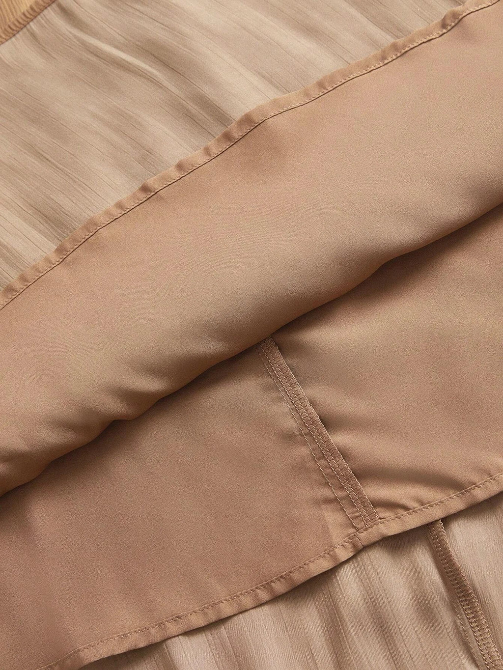 This elegant dress features a soft, shimmering beige fabric that gracefully drapes over the body, highlighting its.