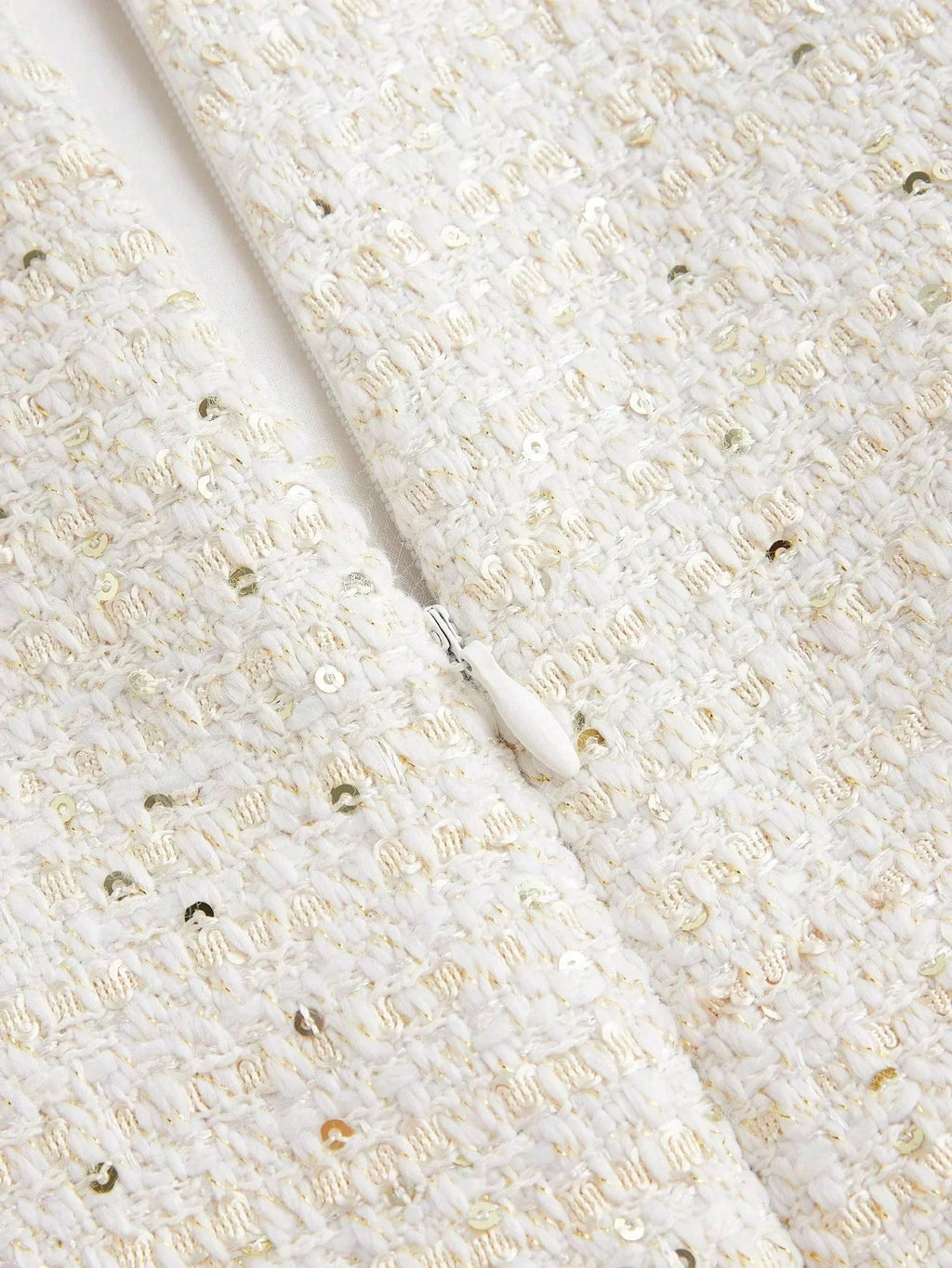 This elegant white dress features a textured fabric adorned with shimmering sequins that catch the light beautifully. Its.