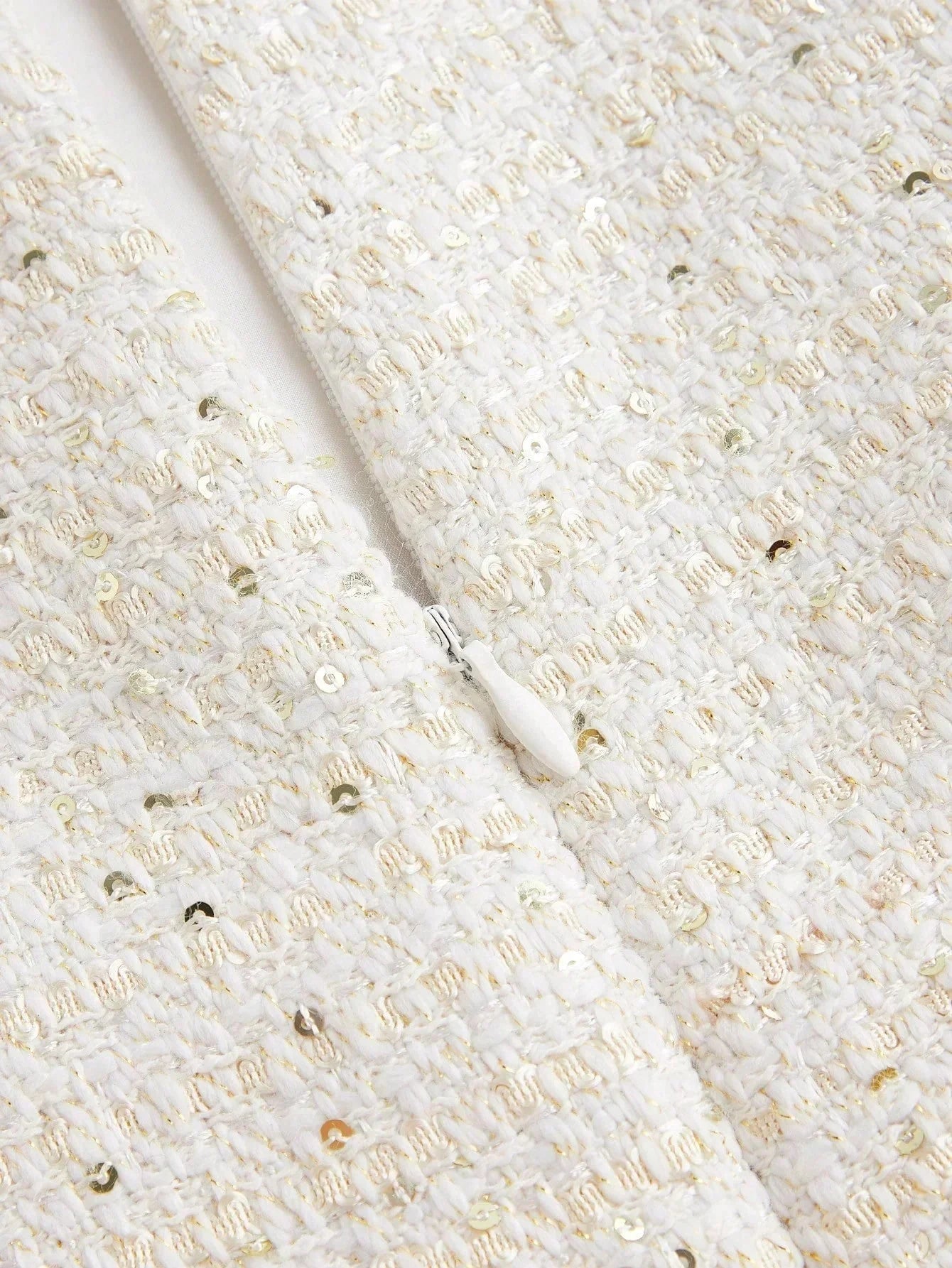 This elegant white dress features a textured fabric adorned with shimmering sequins that catch the light beautifully. Its.