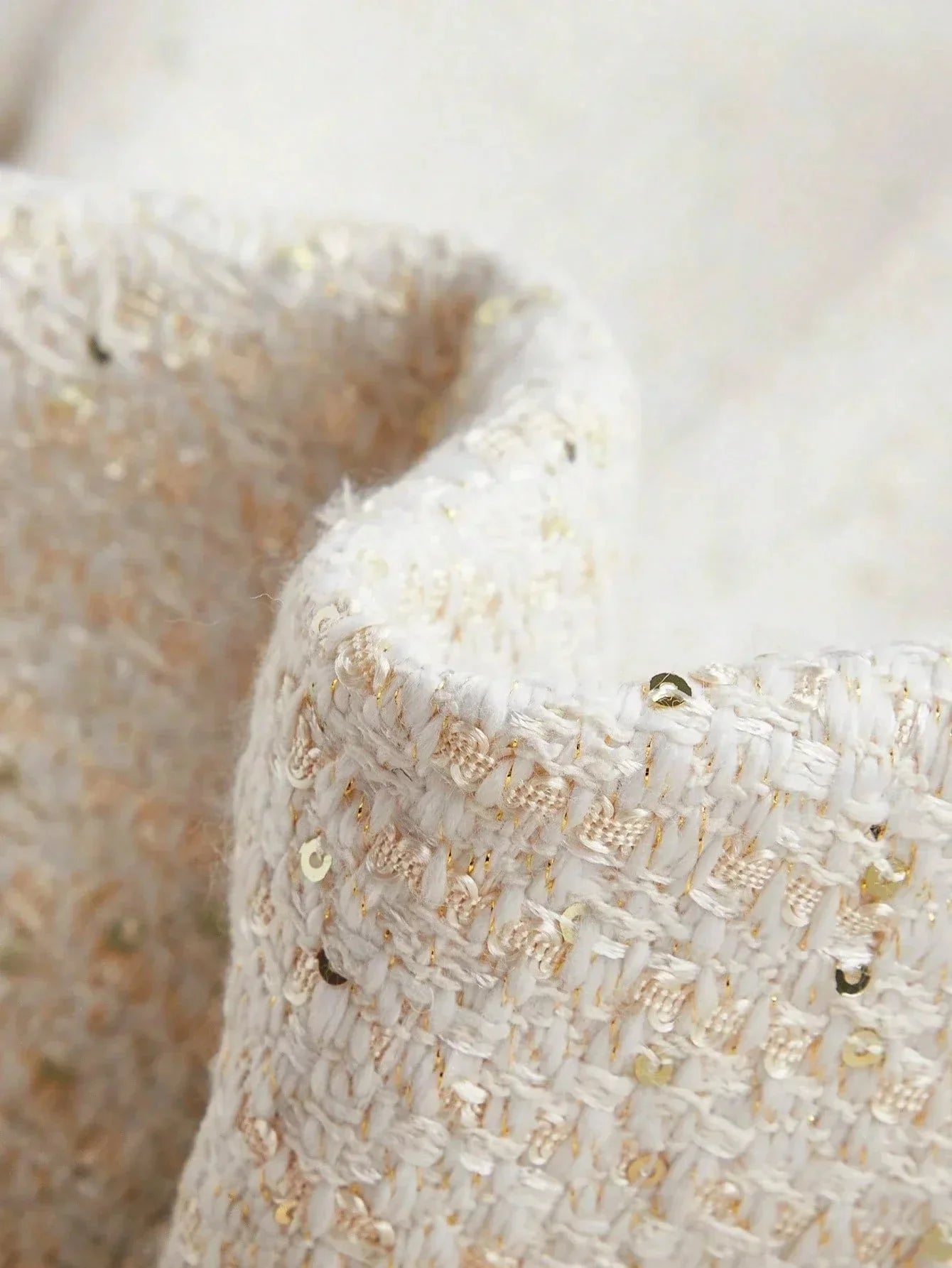 This elegant dress features a soft white fabric adorned with delicate golden threads and shimmering sequins, creating a.