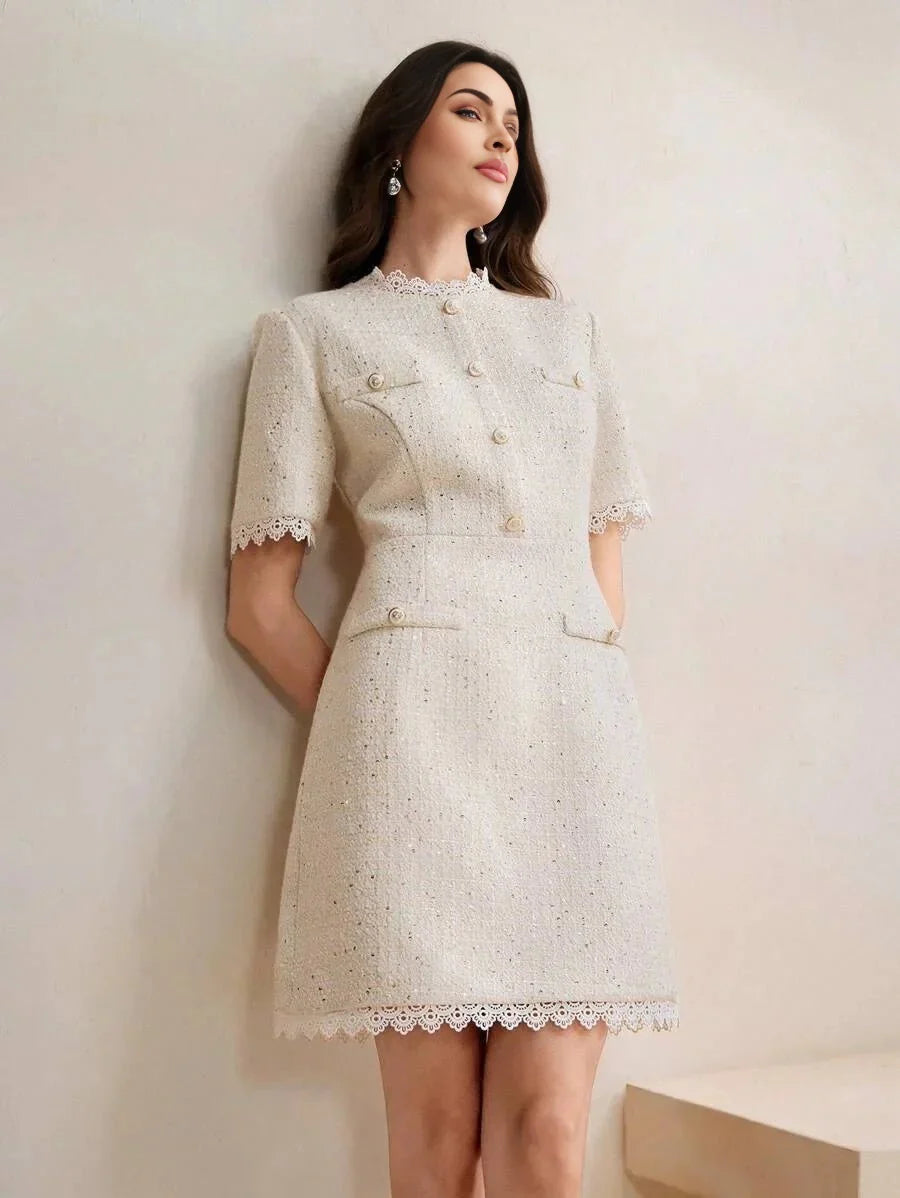 This elegant beige dress features a fitted silhouette with short sleeves and decorative buttons, exuding a chic vintage.