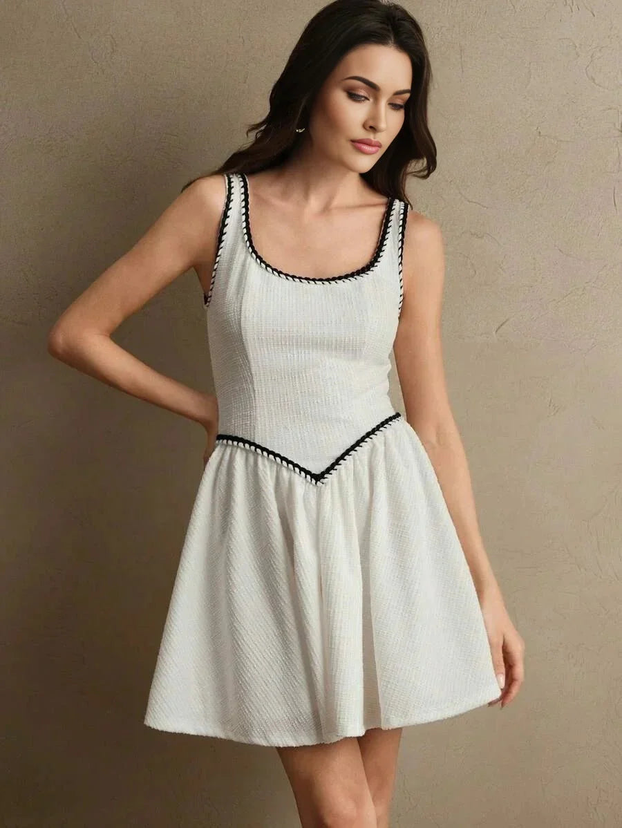 This charming white dress features a flattering fit-and-flare silhouette, accentuated by delicate black trim along the.