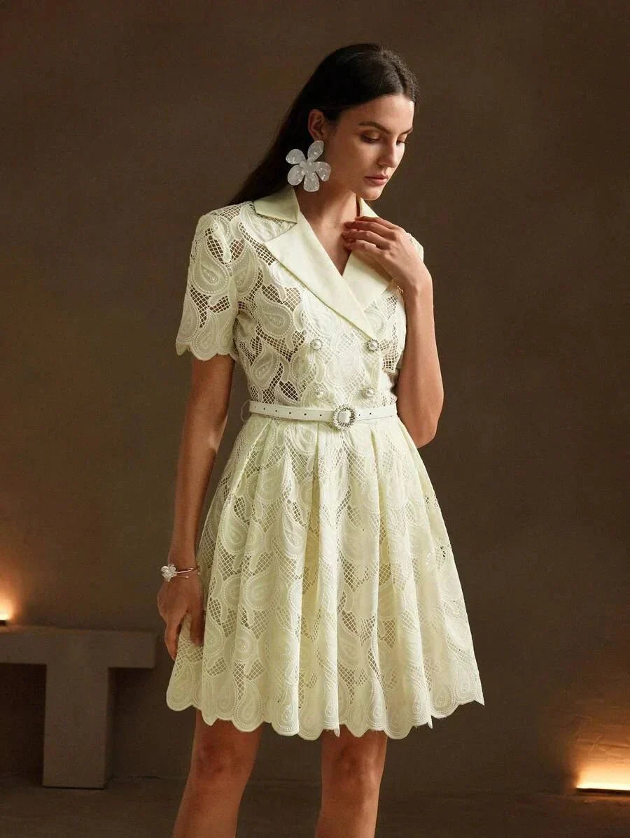 Charming and playful, this light pastel yellow dress features a delicate lace overlay with intricate paisley patterns. The.