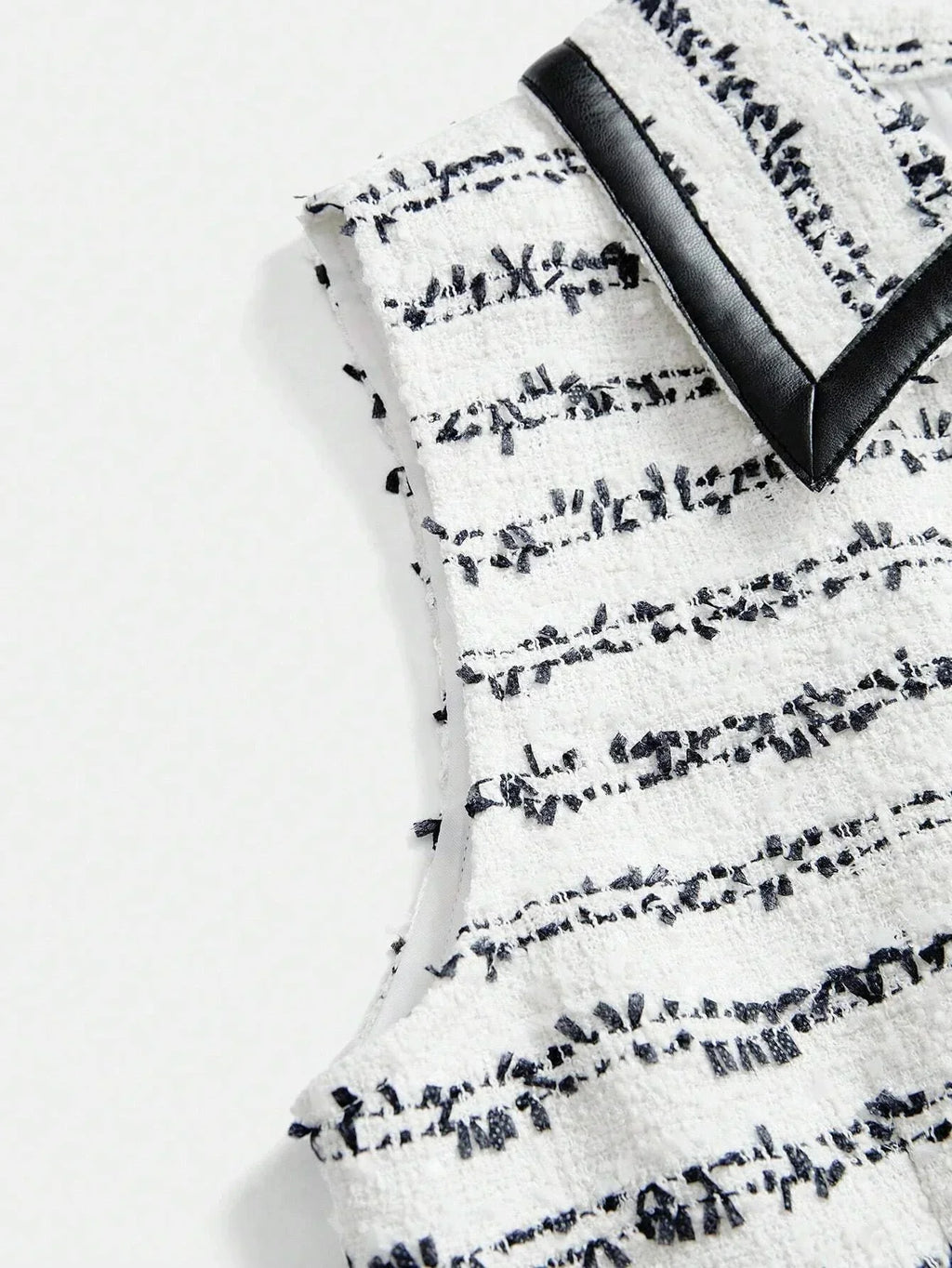 This chic sleeveless dress features a textured white fabric adorned with elegant navy stripes, creating a striking contrast..
