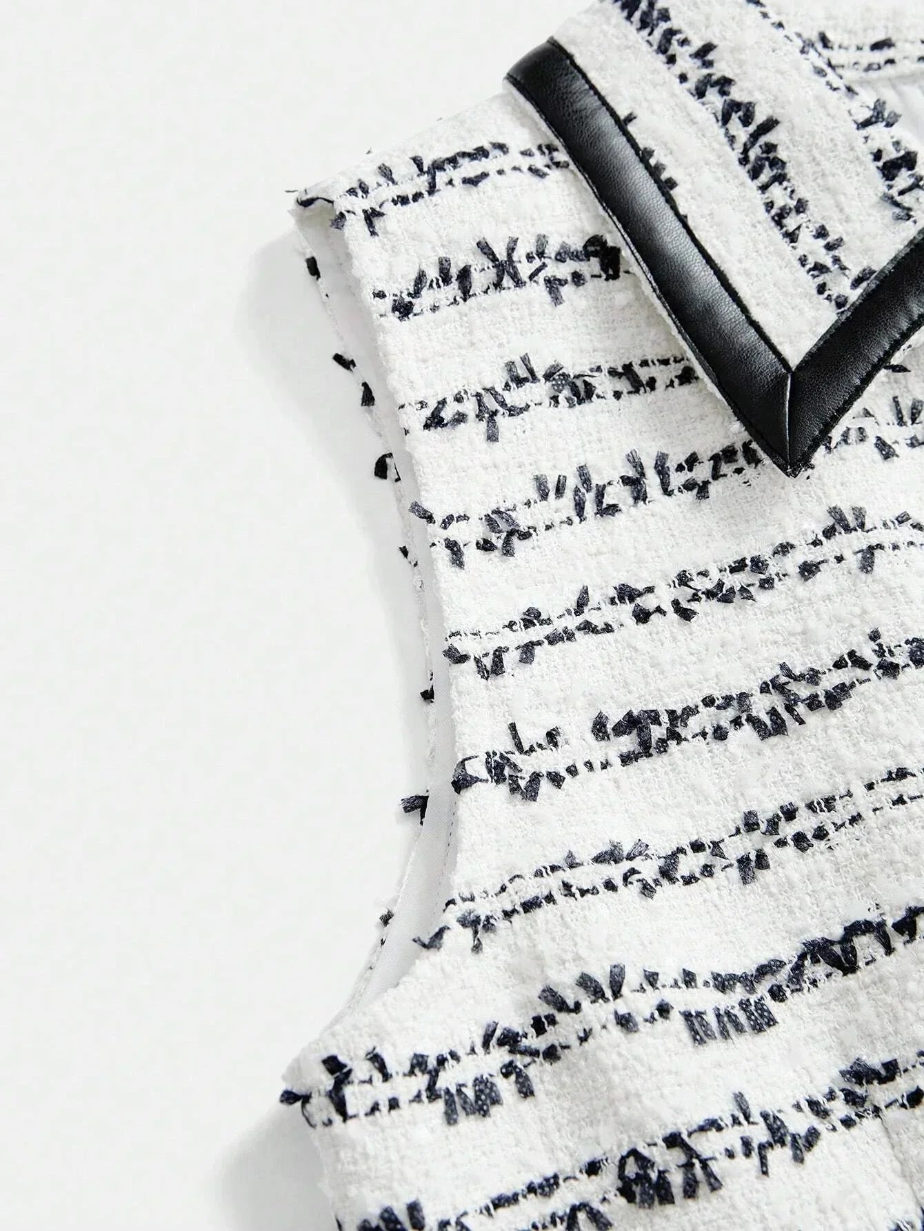 This chic sleeveless dress features a textured white fabric adorned with elegant navy stripes, creating a striking contrast..