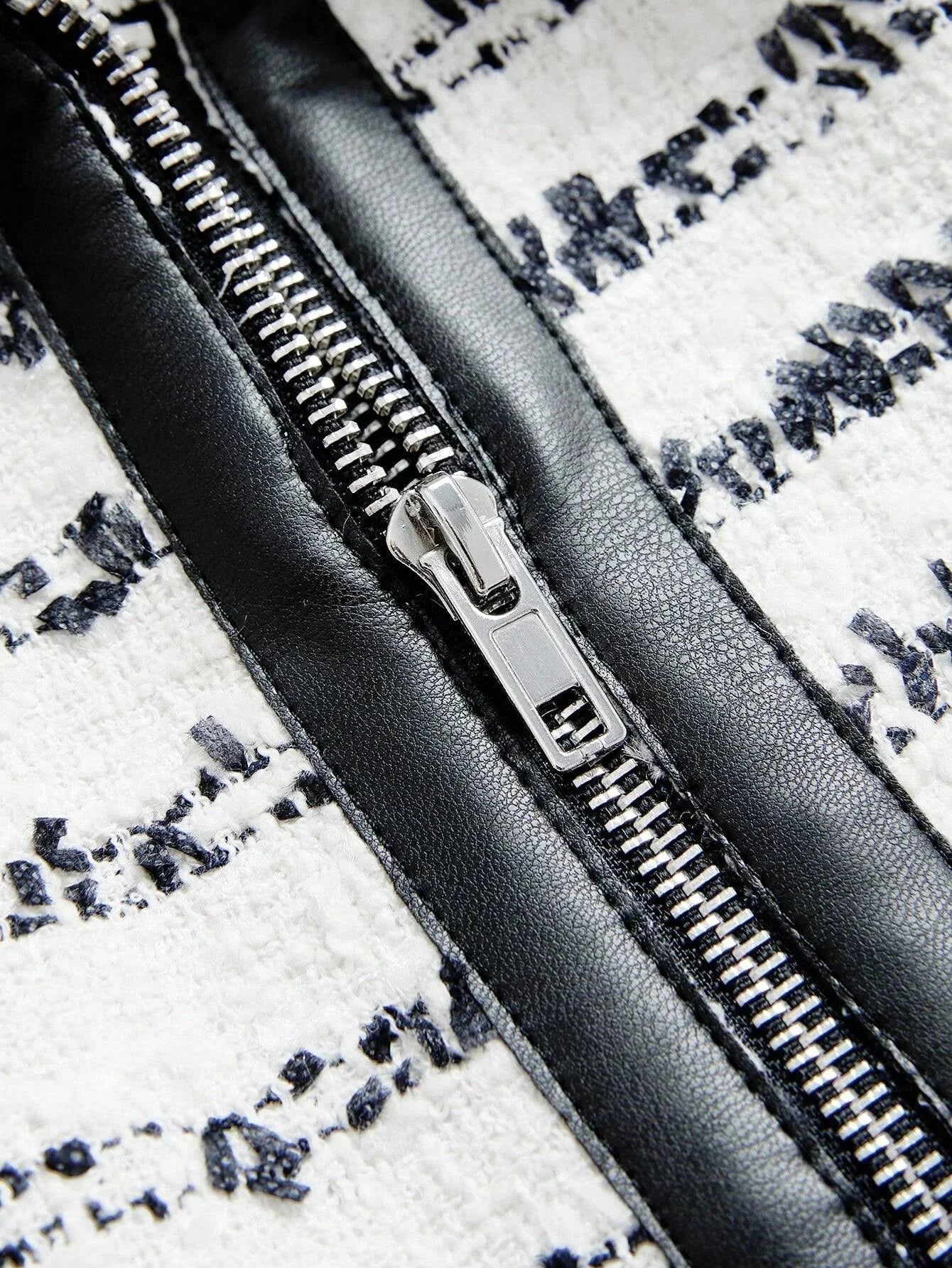 This stylish dress features a chic black and white design with intricate patterns, accentuated by a glossy black zipper that.