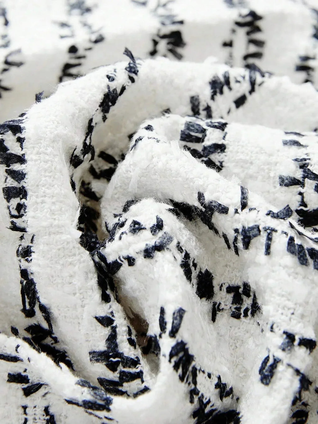 The dress features a chic black and white pattern with a textured fabric that offers a soft, cozy feel. Its relaxed fit.