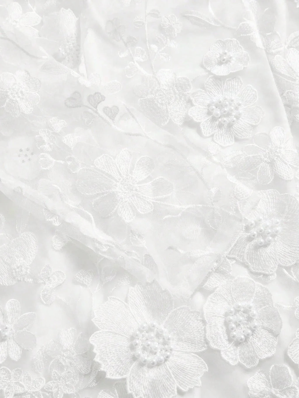 Delicate and ethereal, this stunning white dress features intricate floral embroidery adorned with pearl accents, creating a.