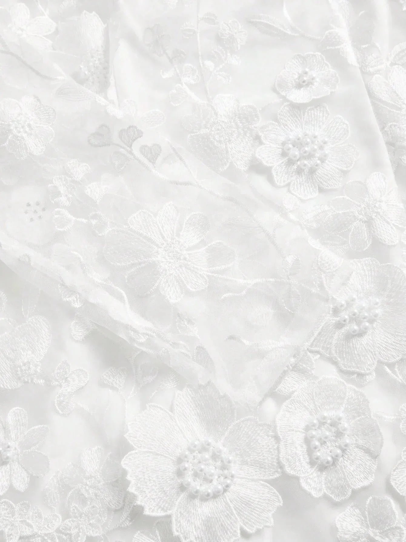 Delicate and ethereal, this stunning white dress features intricate floral embroidery adorned with pearl accents, creating a.