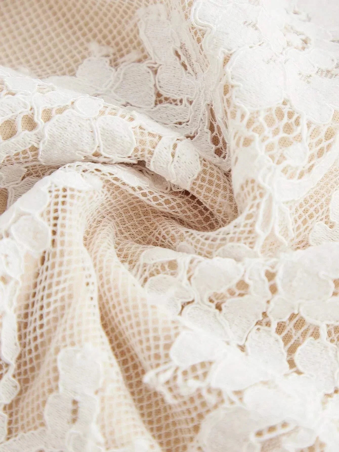 Delicate cream lace fabric with intricate floral patterns creates a romantic and ethereal look, perfect for a summer dress..