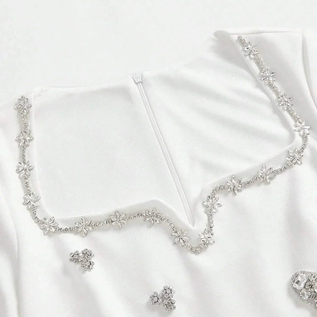 This elegant white dress features a delicate floral beaded neckline that adds a touch of sparkle, perfect for special.