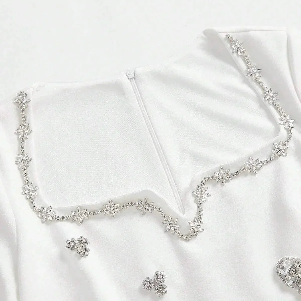 This elegant white dress features a delicate floral beaded neckline that adds a touch of sparkle, perfect for special.
