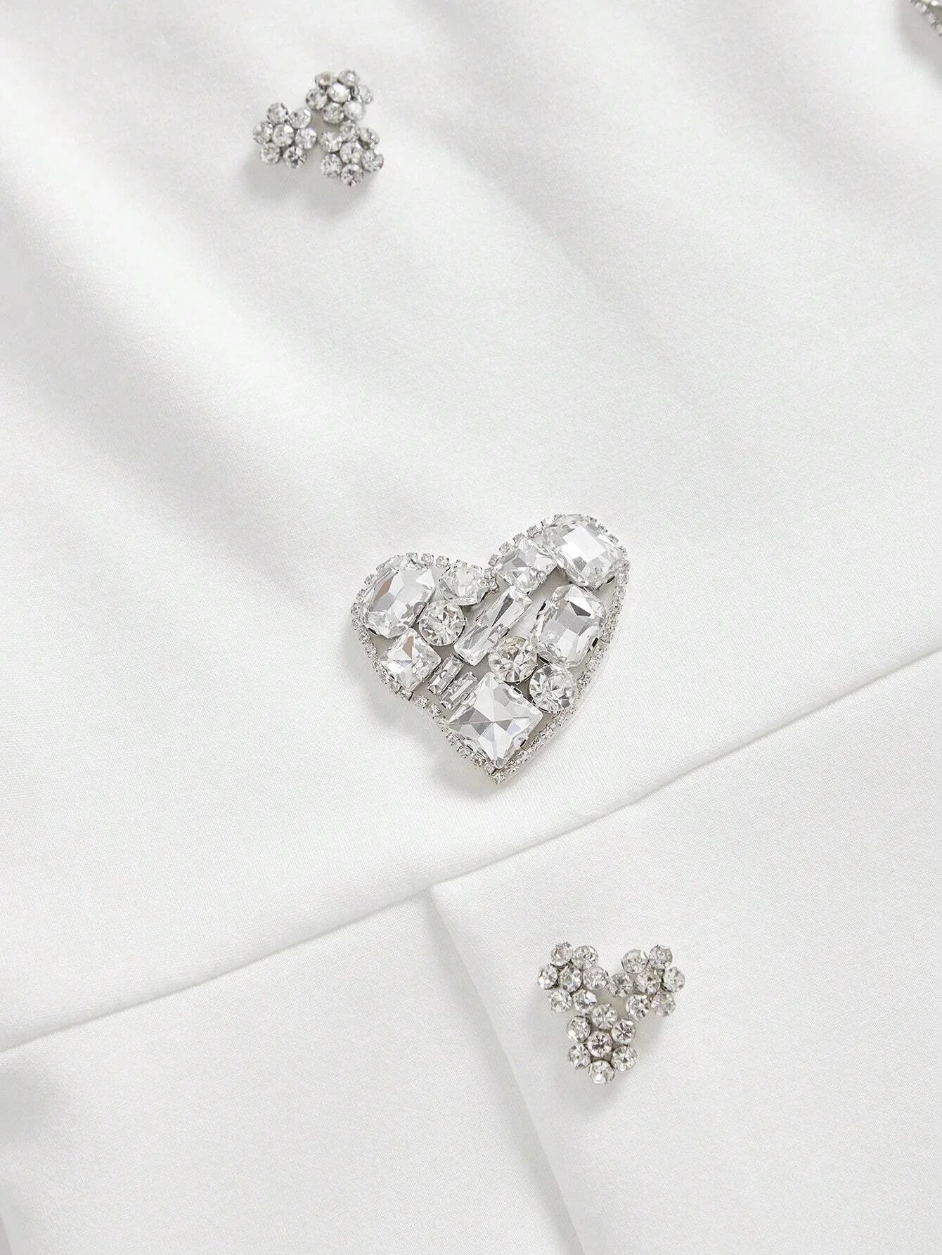 This elegant white dress features a flattering fit, adorned with sparkling crystal embellishments that add a touch of.