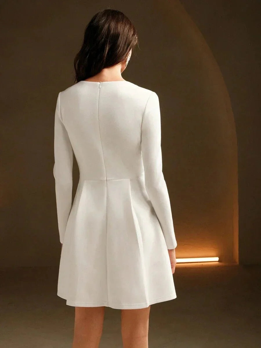 This elegant white dress features a sophisticated silhouette with long sleeves and a flattering fit-and-flare design,.