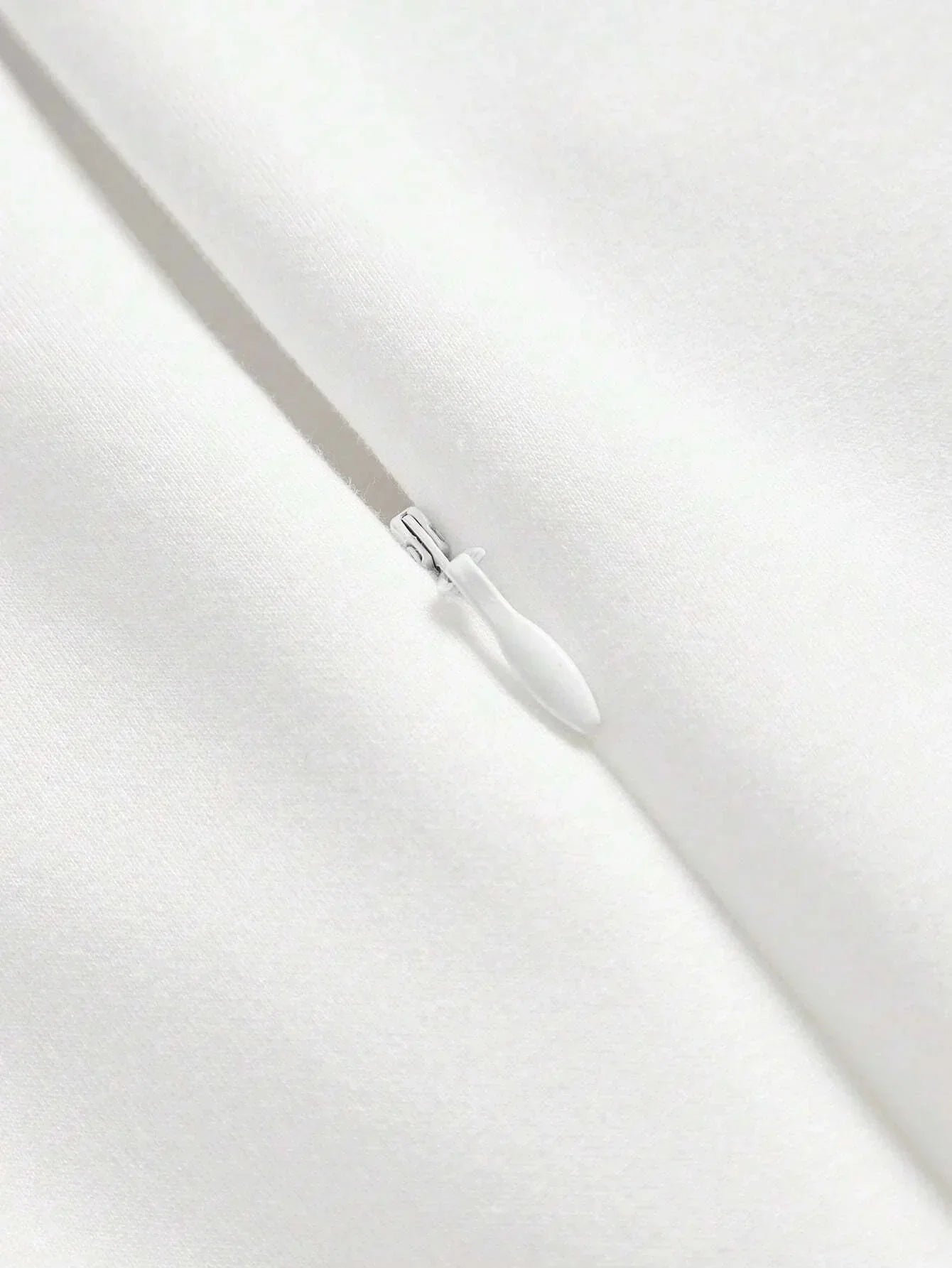 This elegant white dress features a sleek, fitted design that exudes timeless sophistication, made from a soft, smooth.