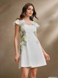 This charming white dress features delicate floral embroidery in soft blues and vibrant greens, creating a stunning contrast.