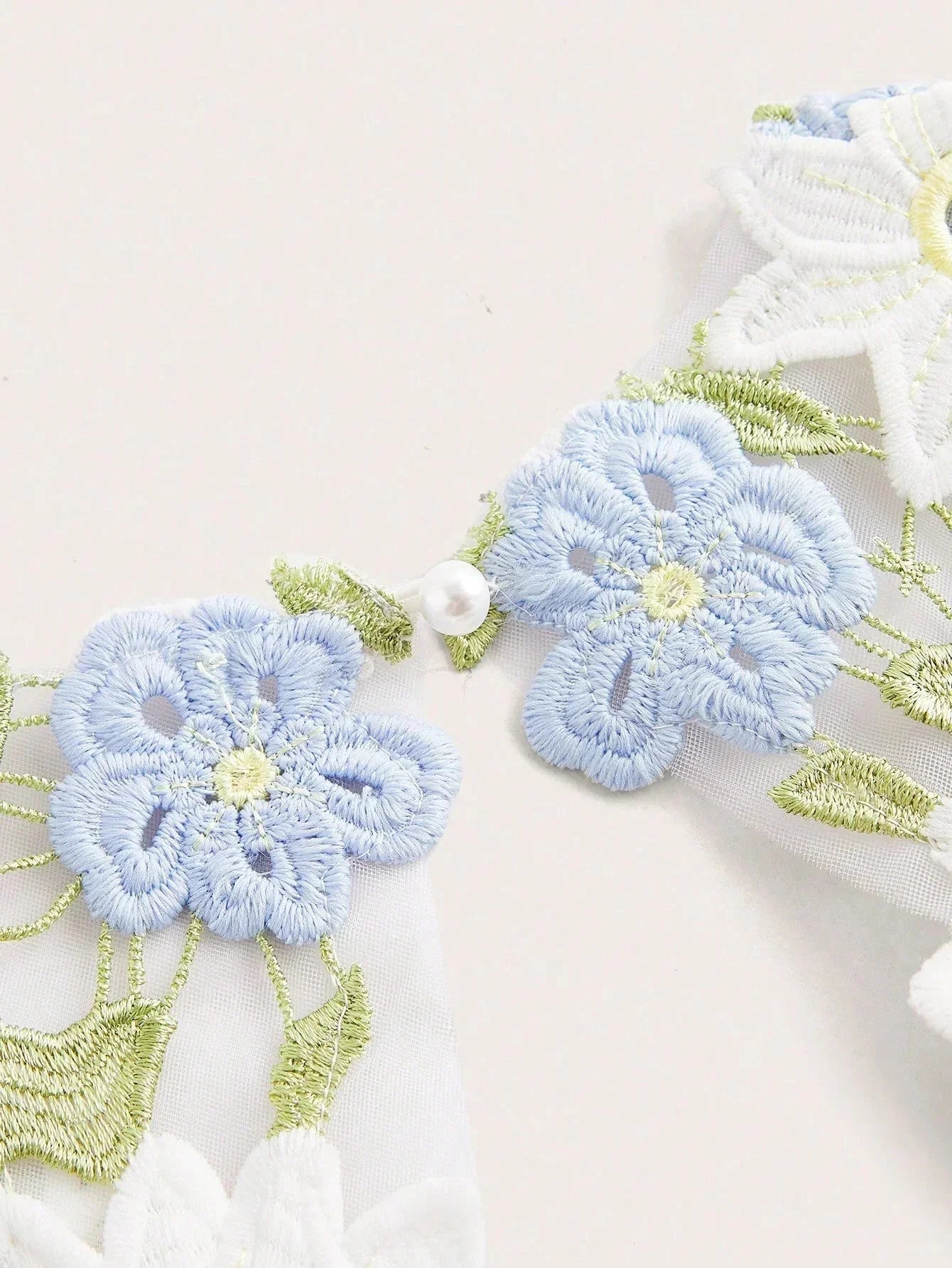 Delicate and ethereal, this dress features a beautiful light blue and white floral embroidery, enhancing its romantic vibe..