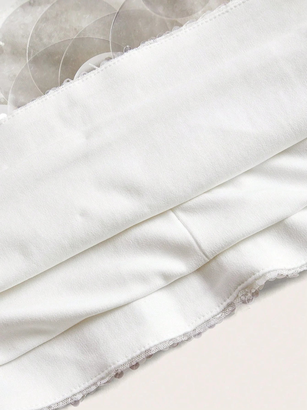 A soft white dress featuring a sleek, fitted bodice and delicate lace trim along the hem, perfect for both casual outings.