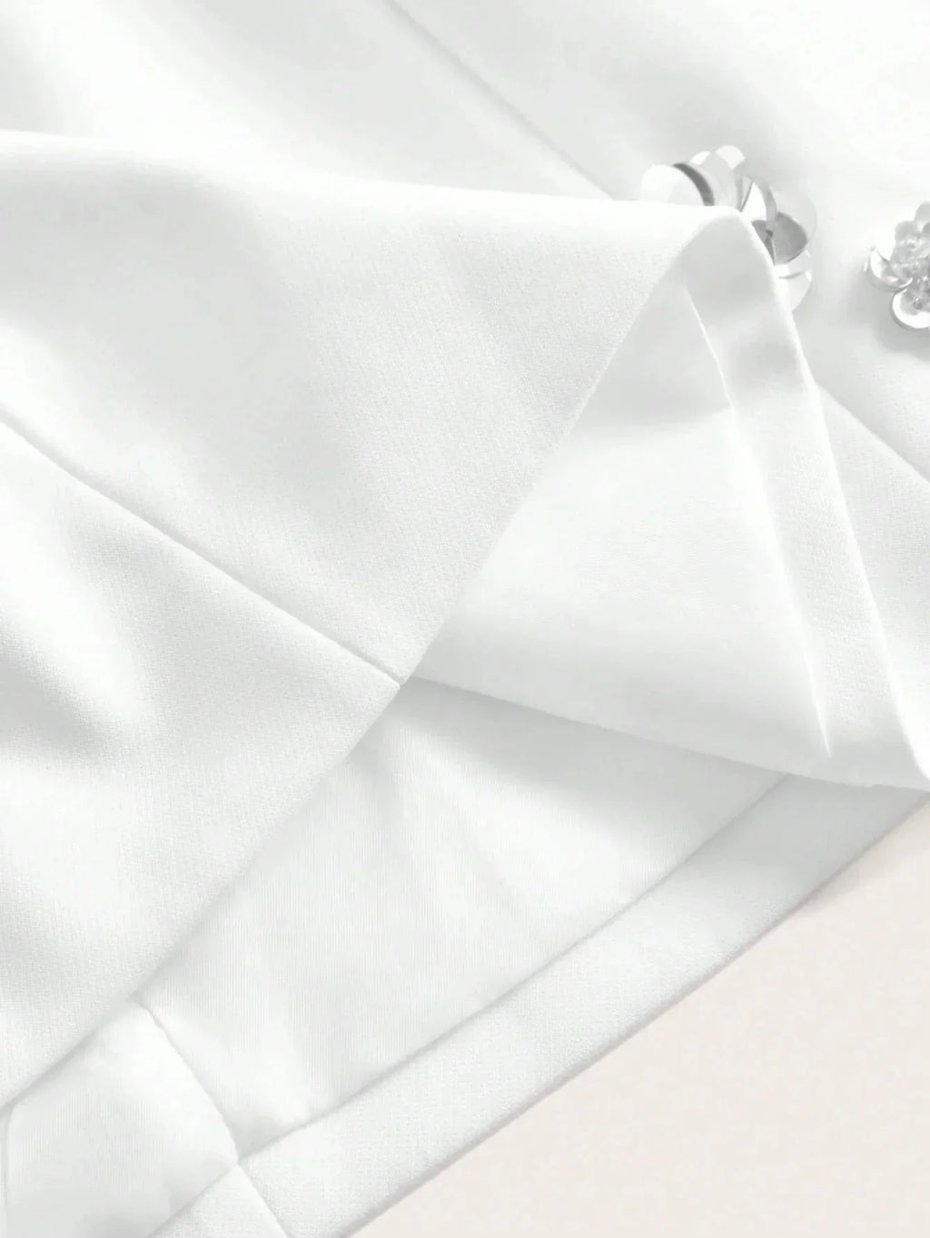 This elegant white dress features a tailored fit with delicate pleating and subtle detailing that adds a touch of.