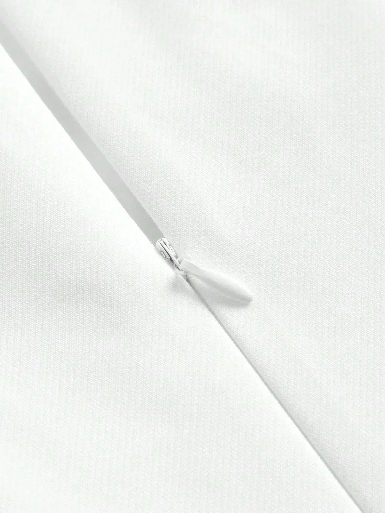 This elegant white dress features a sleek, fitted silhouette and a zipper closure for added convenience, showcasing a.