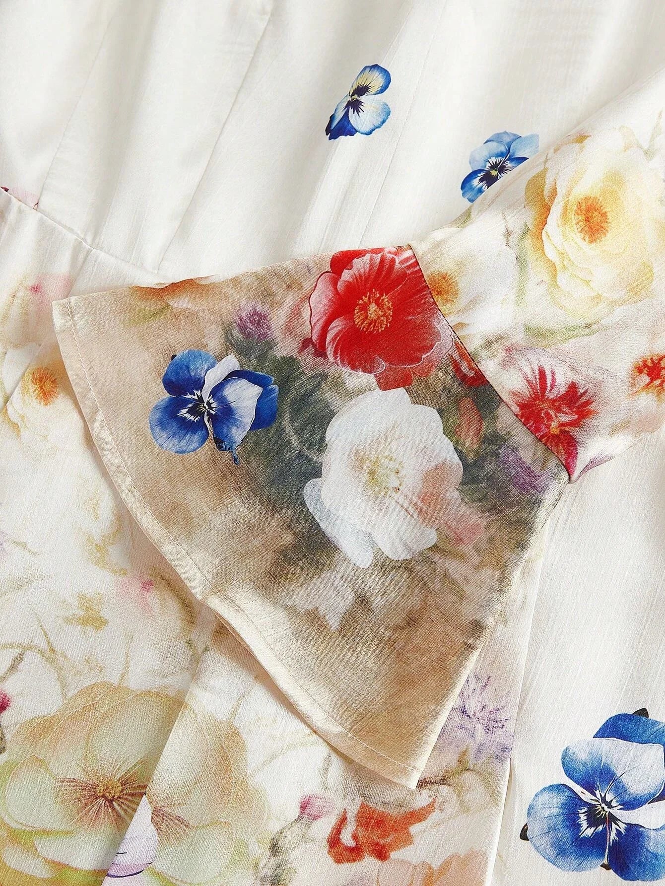 This stunning dress features a delicate floral pattern with vibrant hues of red, blue, and soft yellow blossoms against a.