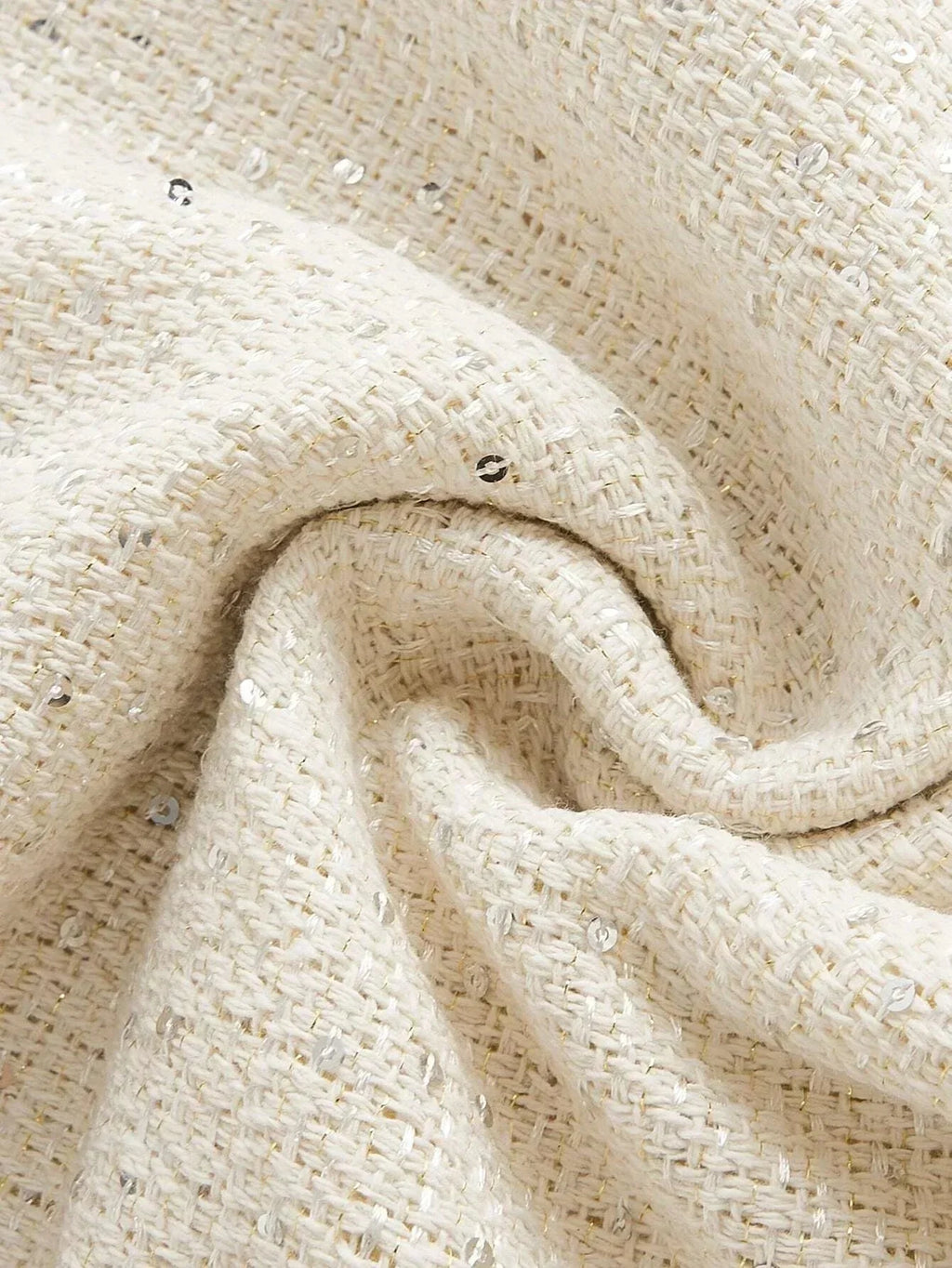 Discover the elegance of this creamy white dress fabric, featuring a chic, textured weave adorned with subtle metallic.