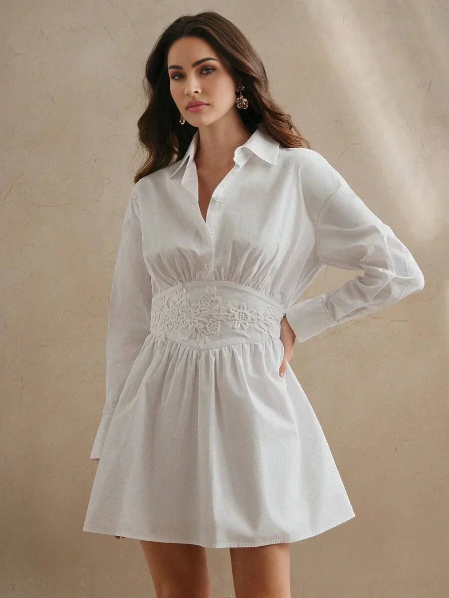 Elevate your wardrobe with this chic white shirt dress featuring a flattering fitted bodice adorned with delicate floral.