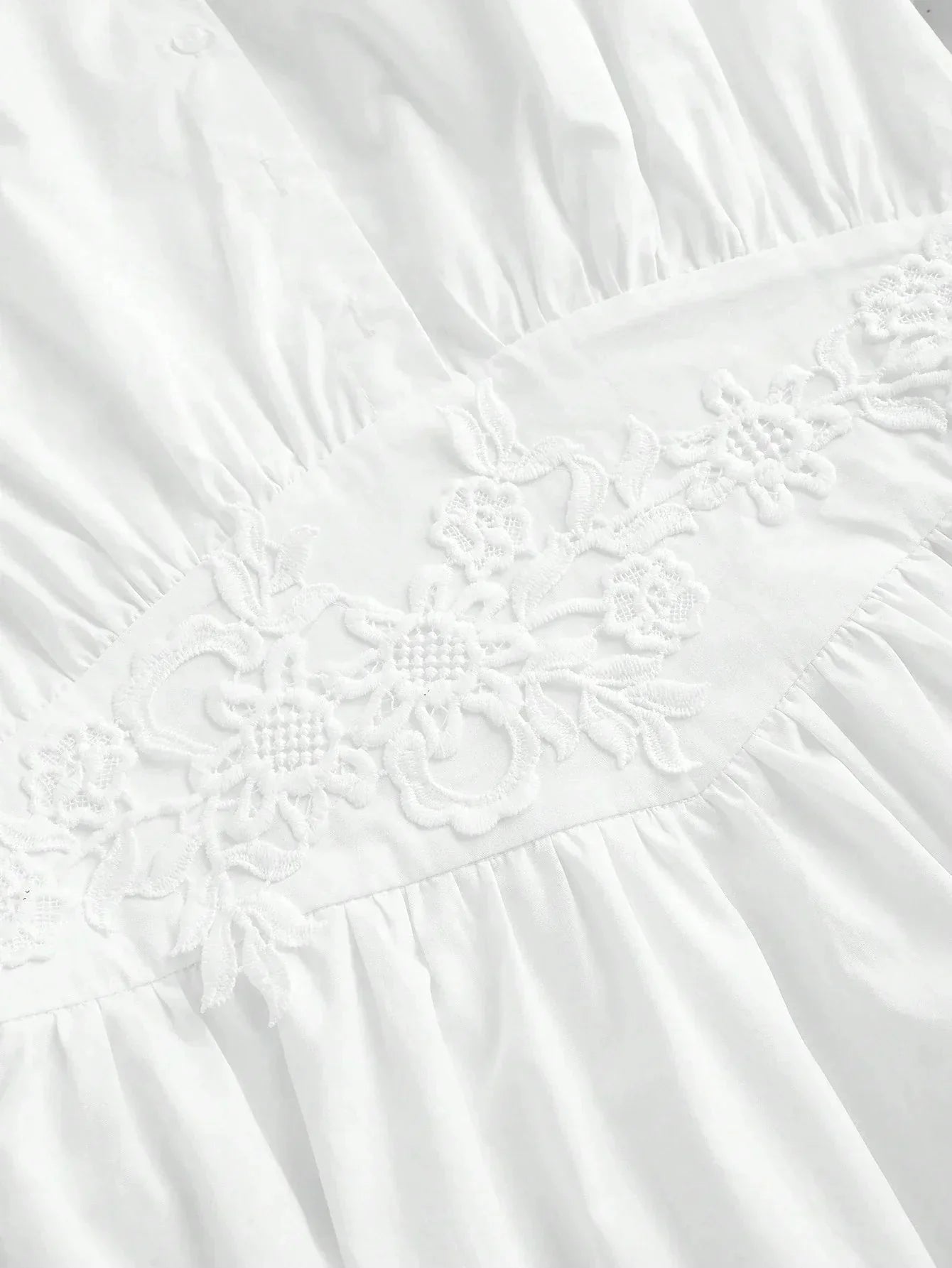 Charming and elegant, this white dress features delicate floral embroidery along the waistline, accentuating its soft,.