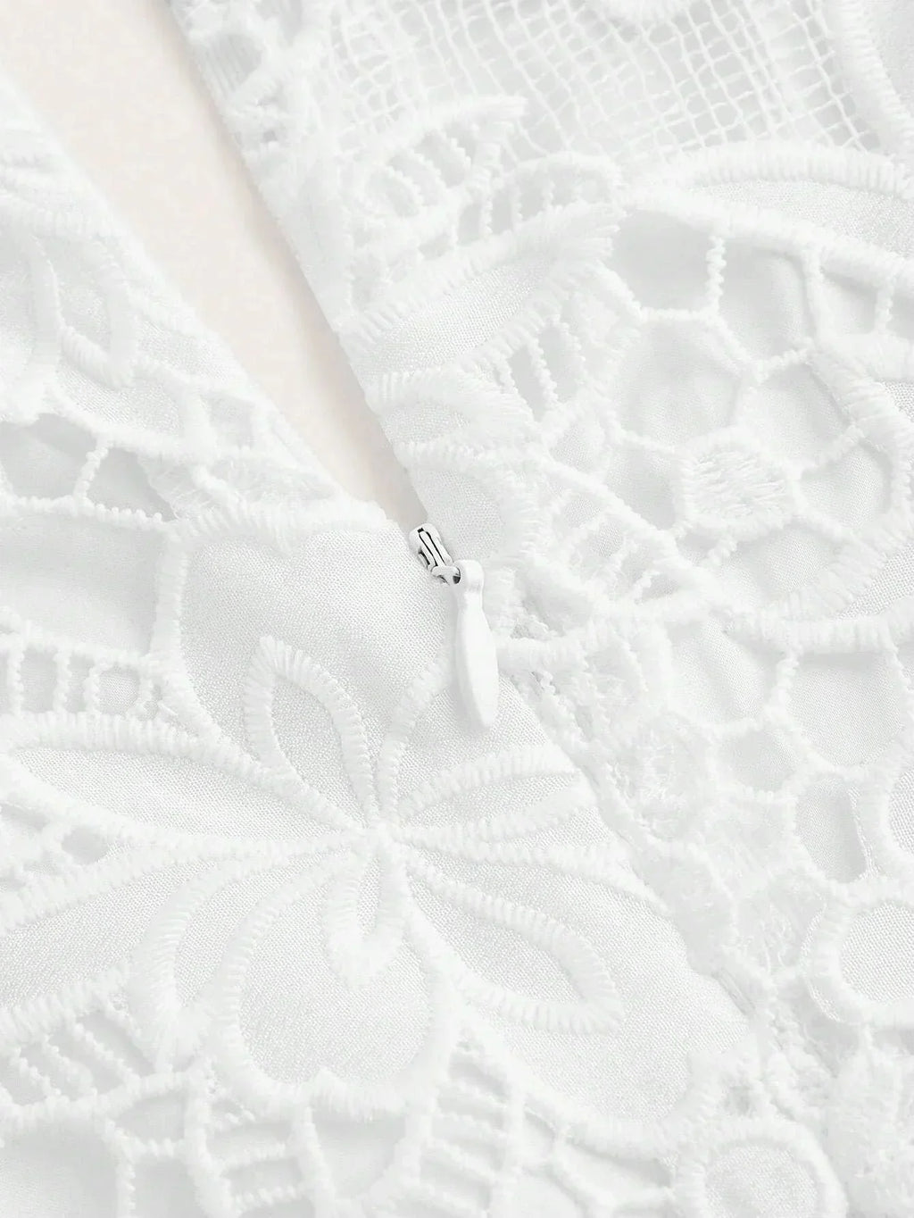 This elegant white dress features intricate floral lace detailing and a soft, flowing fabric that drapes beautifully..