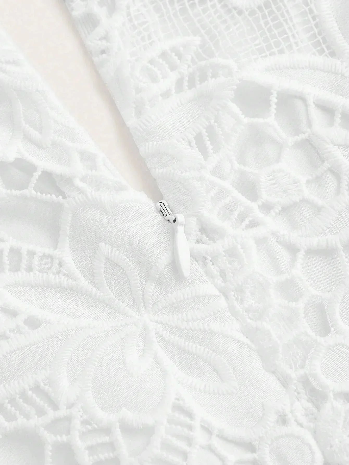 This elegant white dress features intricate floral lace detailing and a soft, flowing fabric that drapes beautifully..