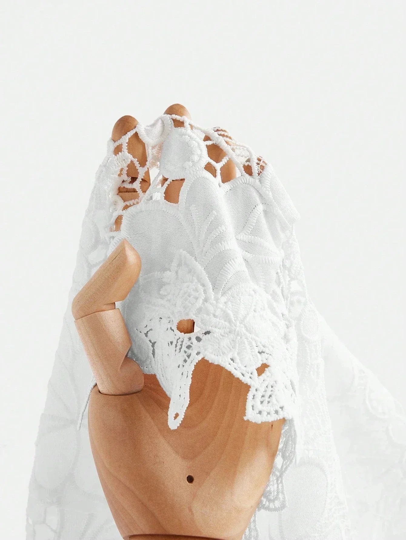 Delicate white lace dress showcasing intricate floral patterns and a romantic, flowing silhouette. Made from lightweight.
