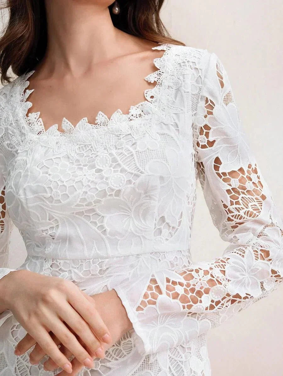 This elegant white dress features intricate floral lace detailing with a scalloped neckline and bell sleeves, exuding a.