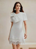 This elegant white dress features a chic bow detail at the neckline and short puff sleeves, designed for a flattering fit.