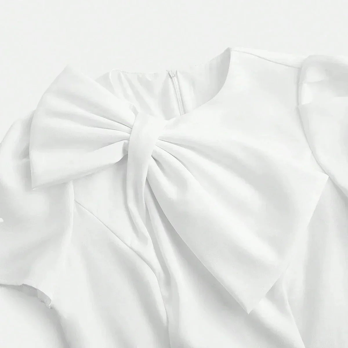 Elegant and ethereal, this white dress features a delicate bow at the neckline, combining sophistication with a touch of.