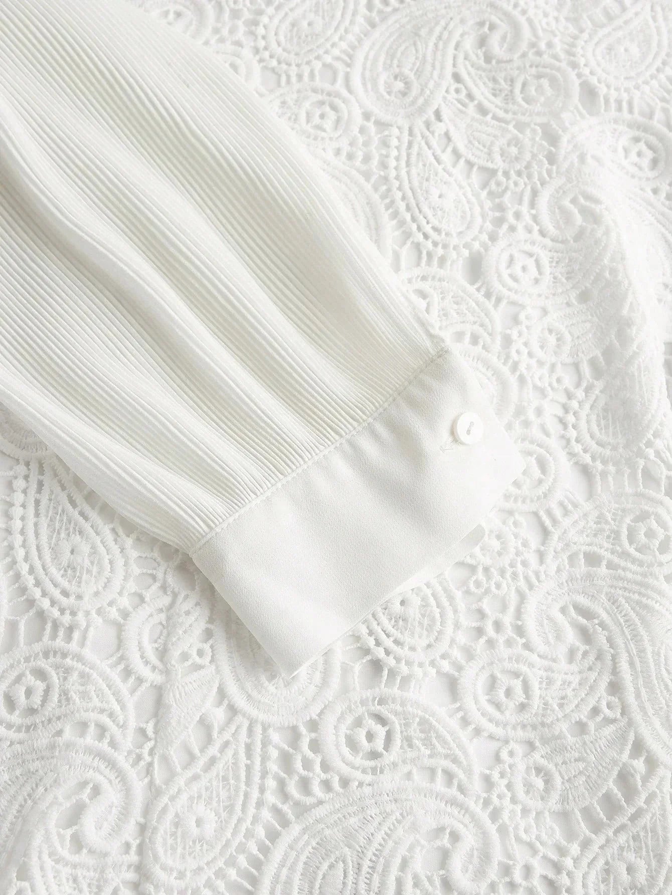 This elegant white dress features delicate pleated sleeves and intricate lace detailing that adds a touch of romance. The.