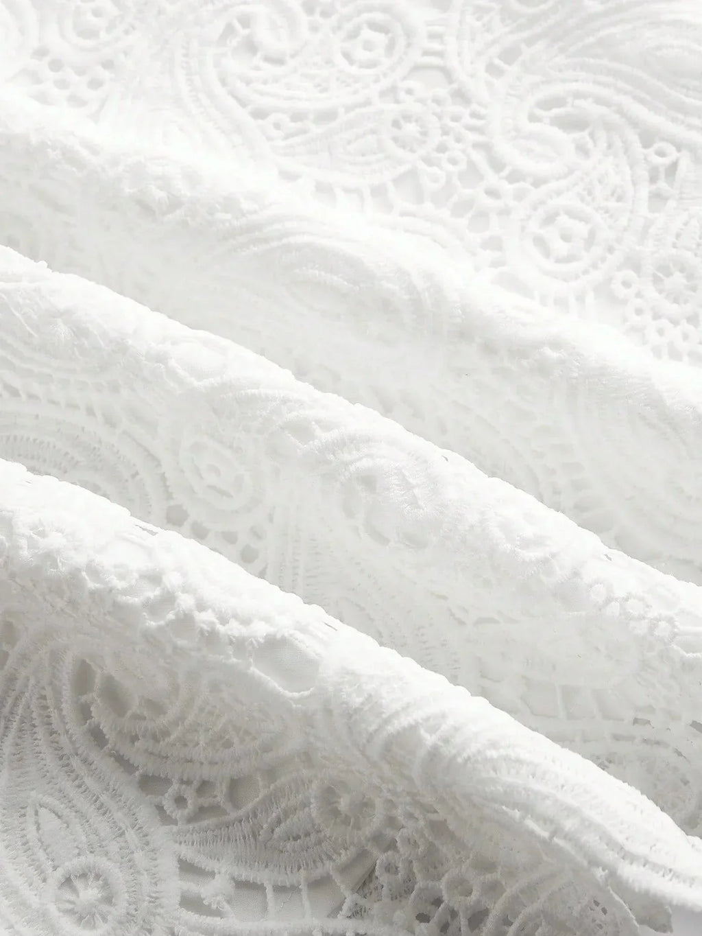 Delicate and elegant, this white lace fabric features intricate patterns that evoke a sense of timeless sophistication. The.
