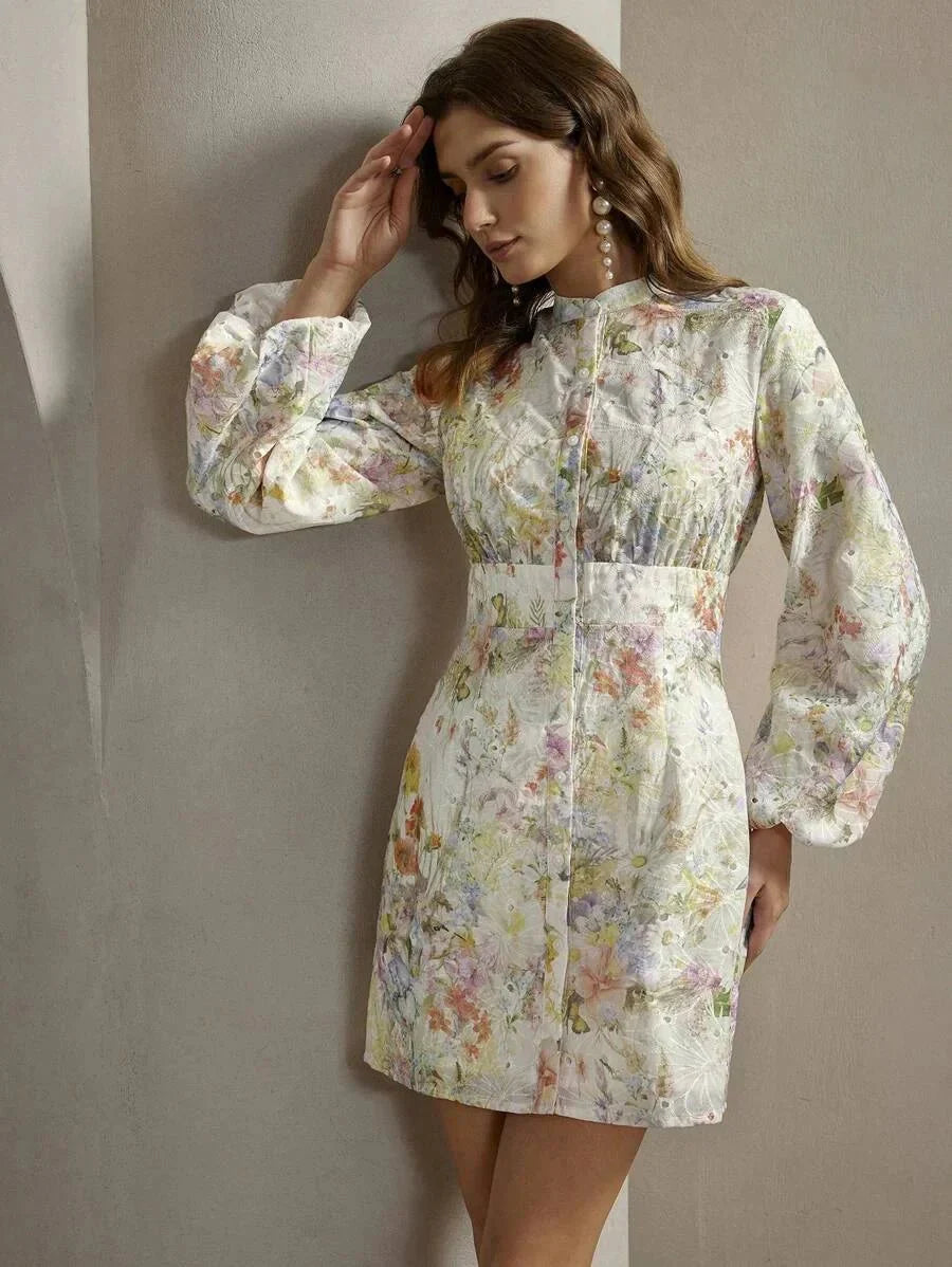 This elegant floral dress features a soft, pastel color palette with a modern, fitted silhouette that gently flares at the.