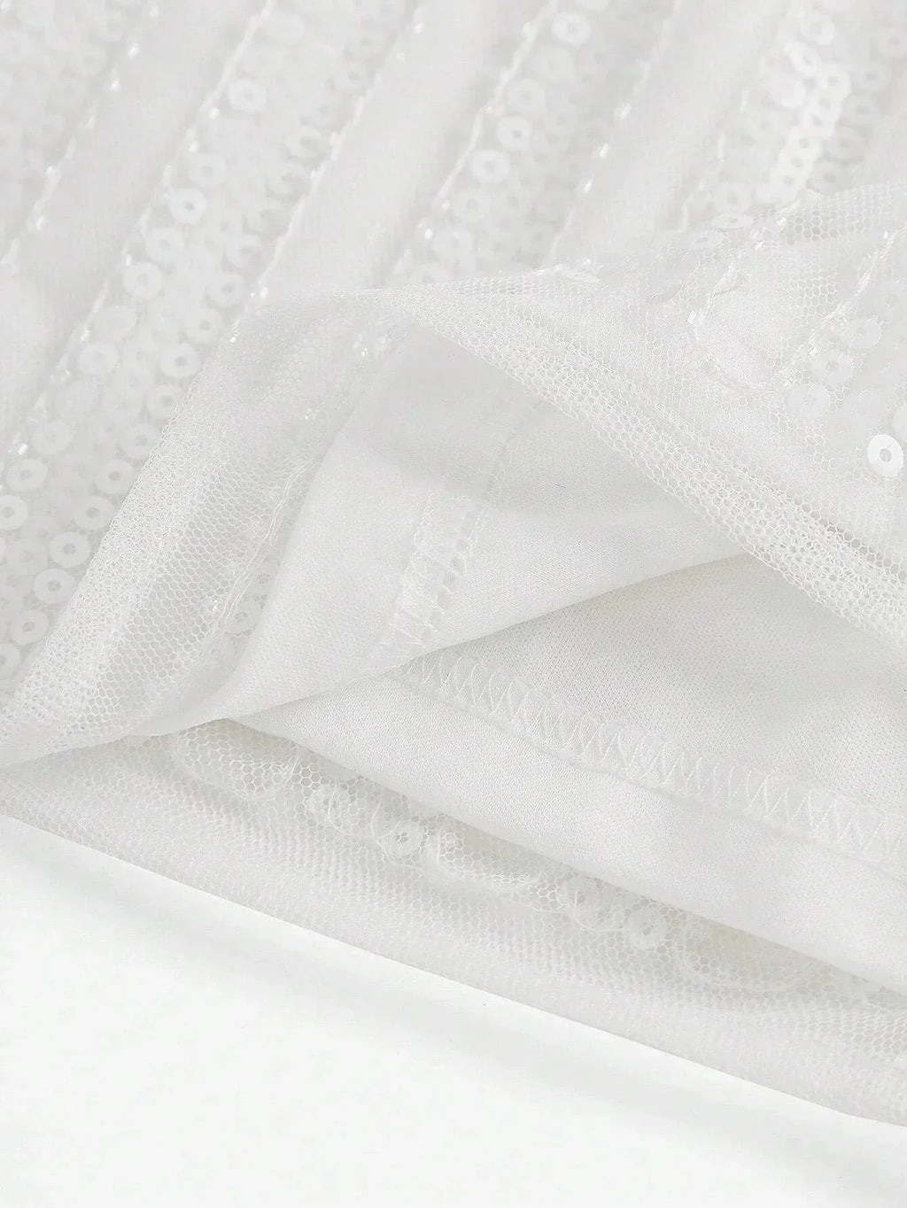 This elegant white dress features shimmering sequins and a flowing design that exudes sophistication. The lightweight fabric.