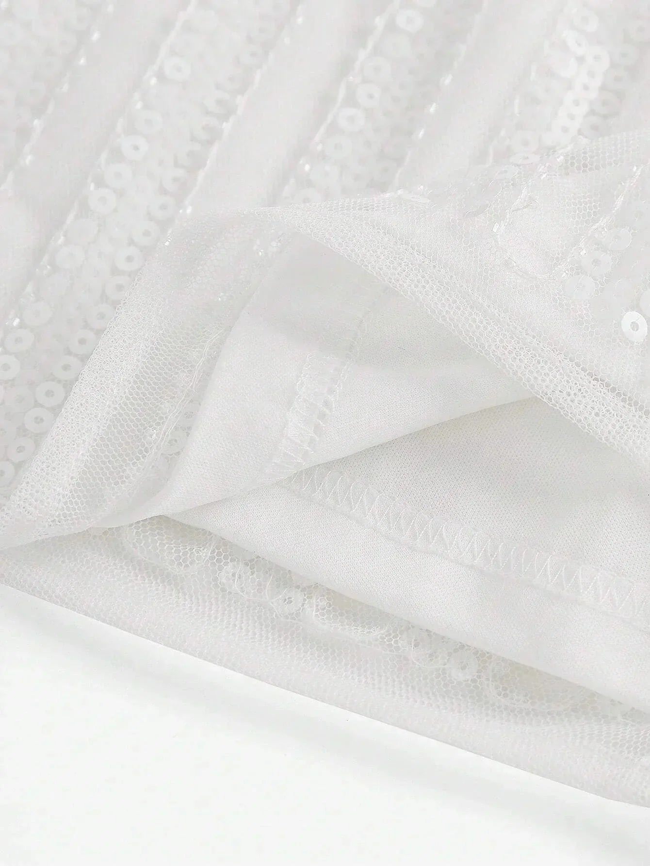 This elegant white dress features shimmering sequins and a flowing design that exudes sophistication. The lightweight fabric.