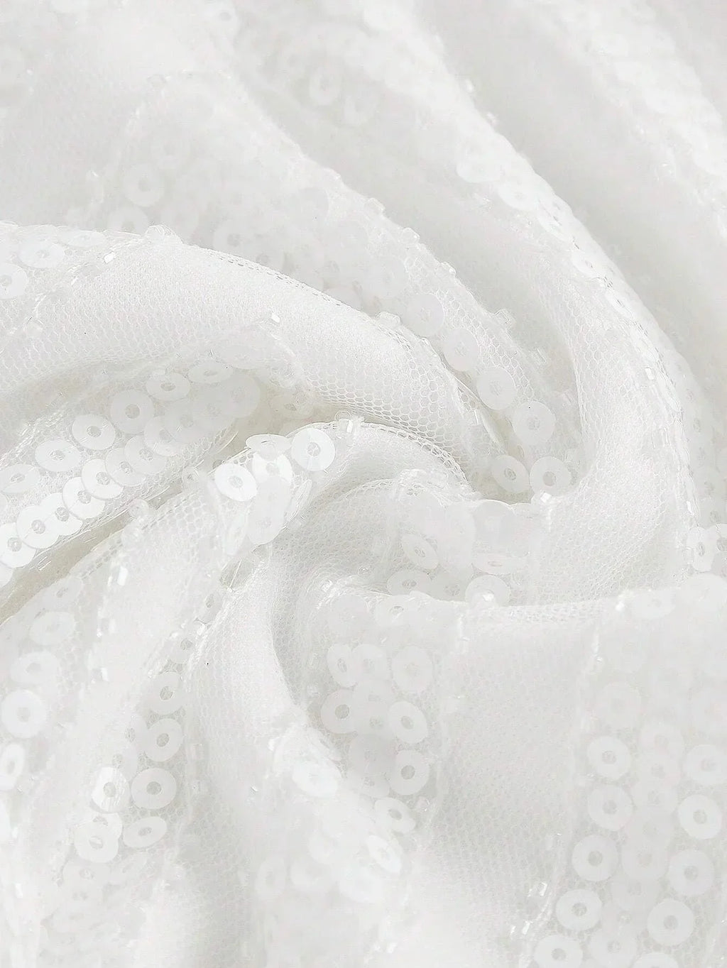This elegant white dress features a sparkling sequined fabric that catches the light beautifully, giving it a stunningly.