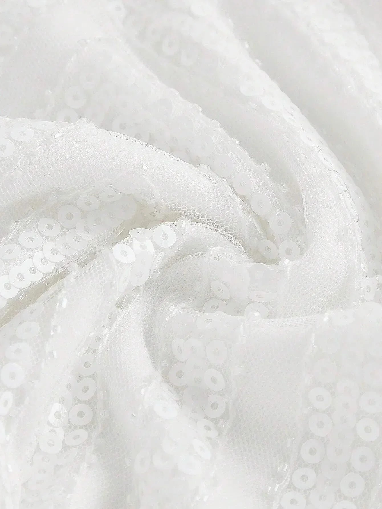 This elegant white dress features a sparkling sequined fabric that catches the light beautifully, giving it a stunningly.