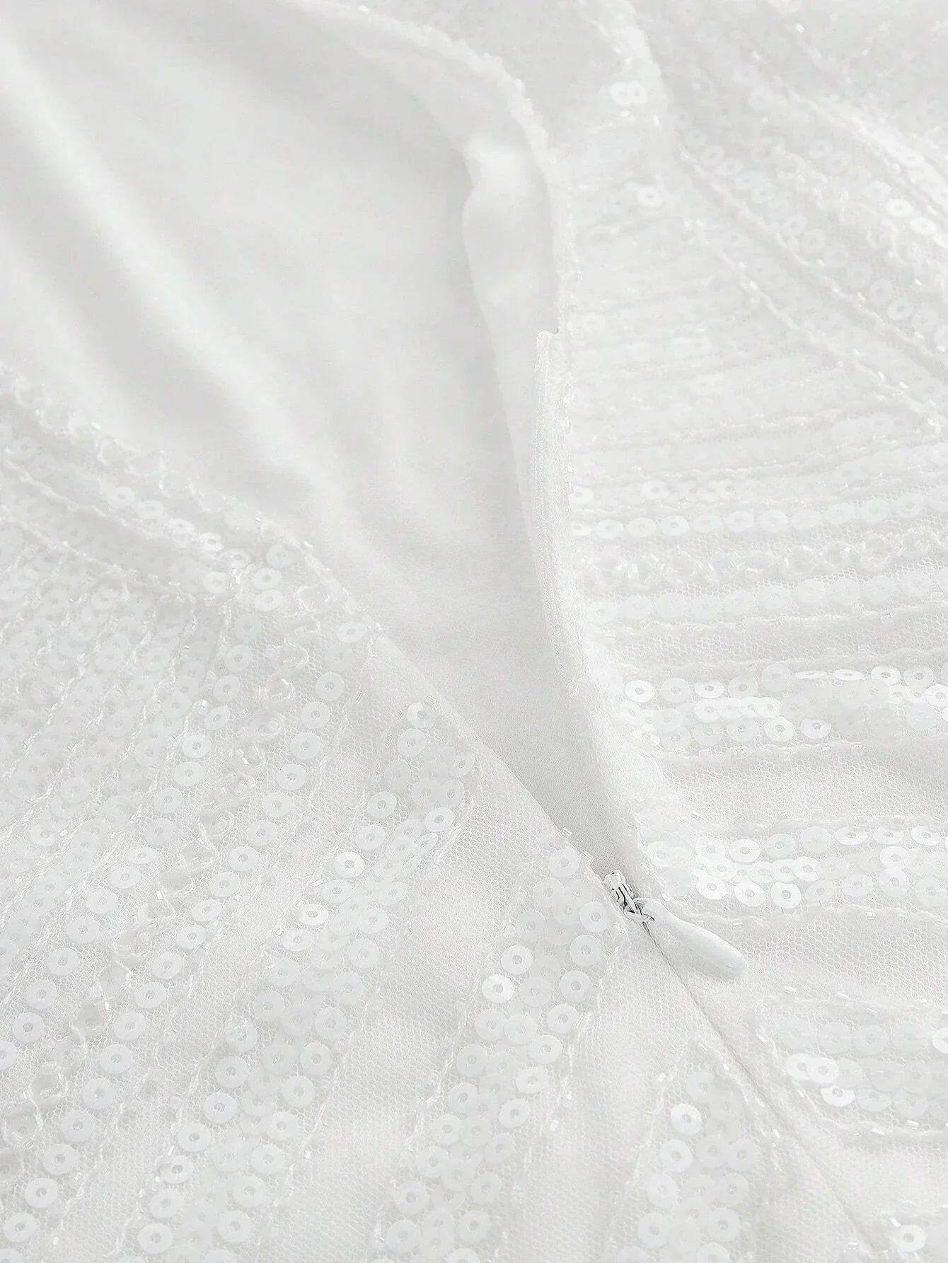 This elegant white dress features a shimmering sequin design that catches the light beautifully, offering a glamorous touch.